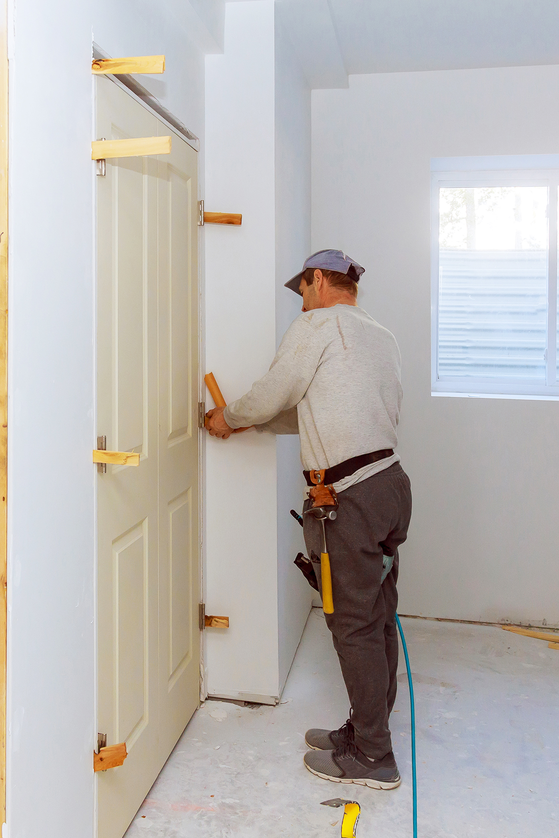 Craftsperson carefully installing a door inside a home