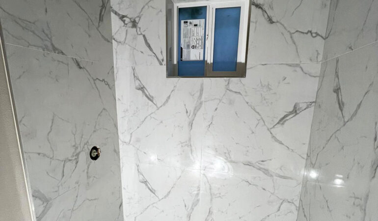Bathroom remodel with white marble-effect walls